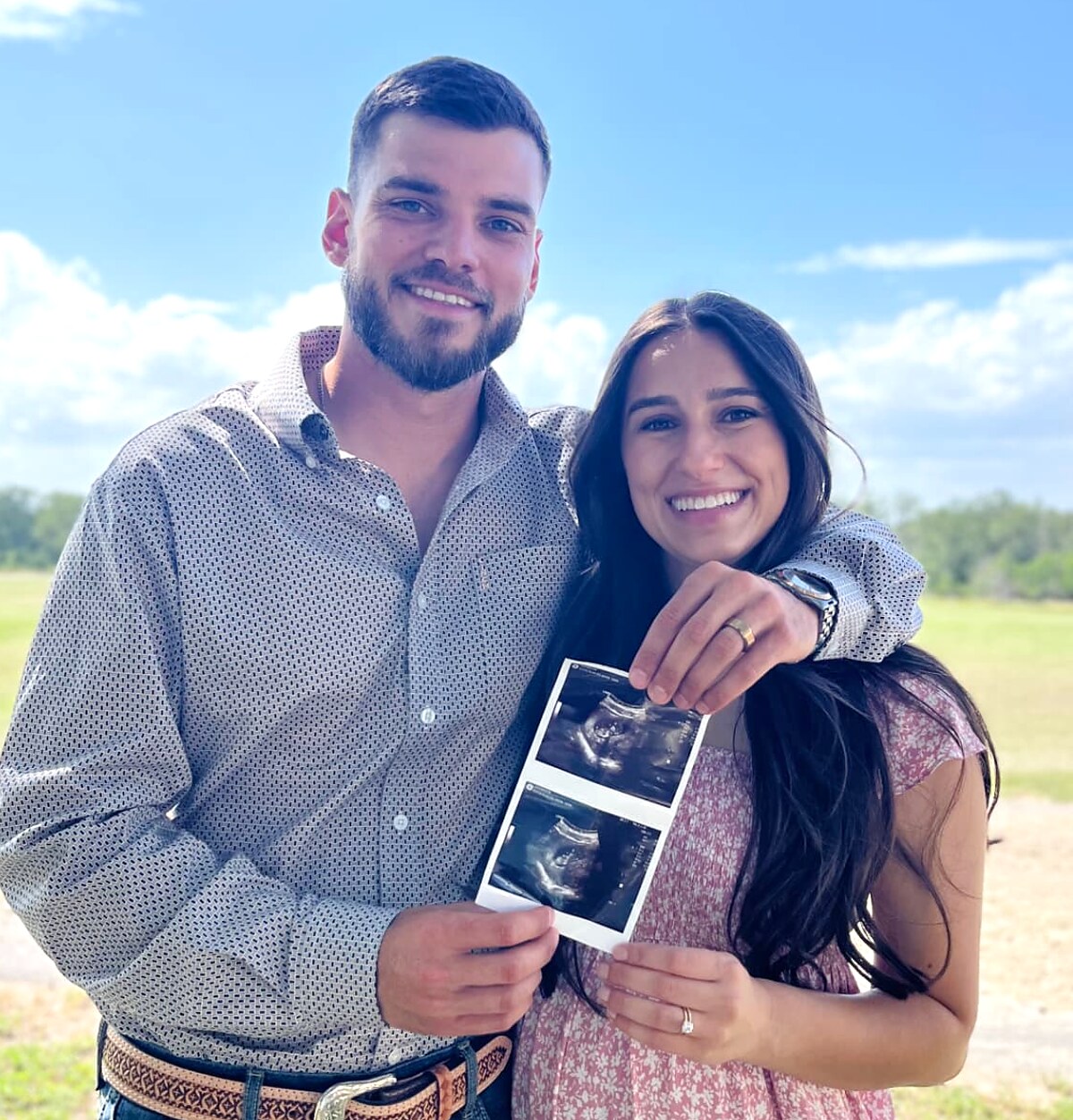 Jason and his wife outdoors holding their first ultrasound photos